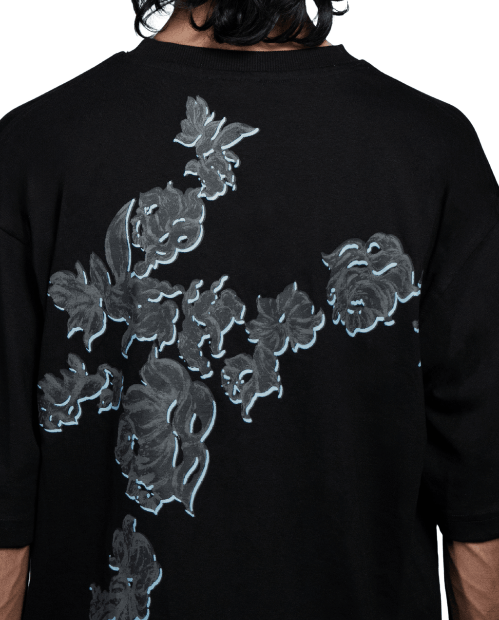 Back view of black oversized cotton t-shirt showing continuous blue bloom print - VYVHR
